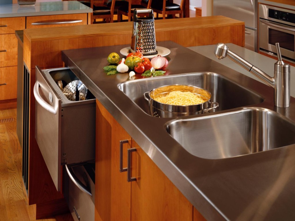 Stainless steel island countertop with integrated double sink & under-counter appliances. | Photo Source: HGTV